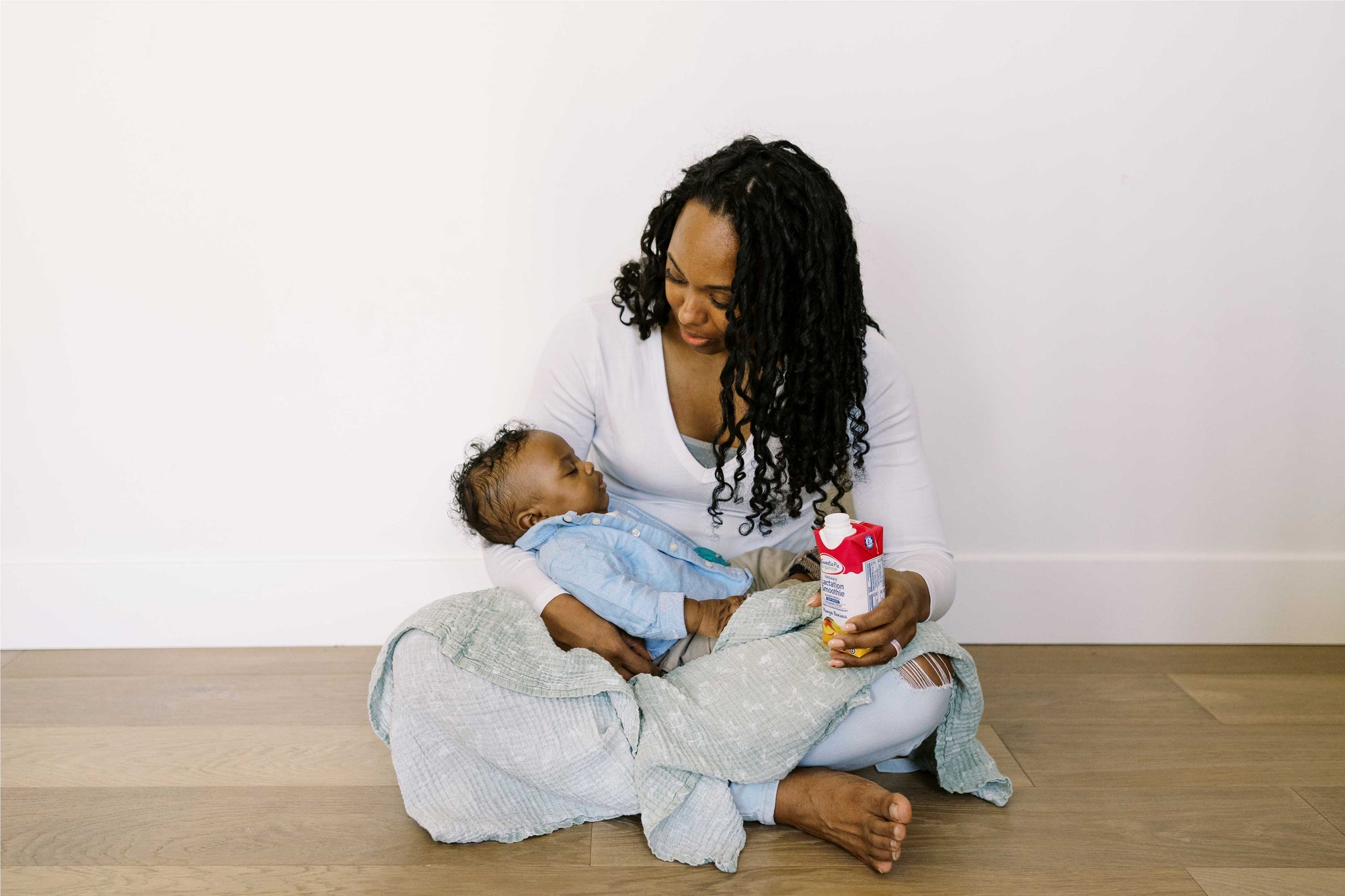 Parent holding infant and lactation smootie