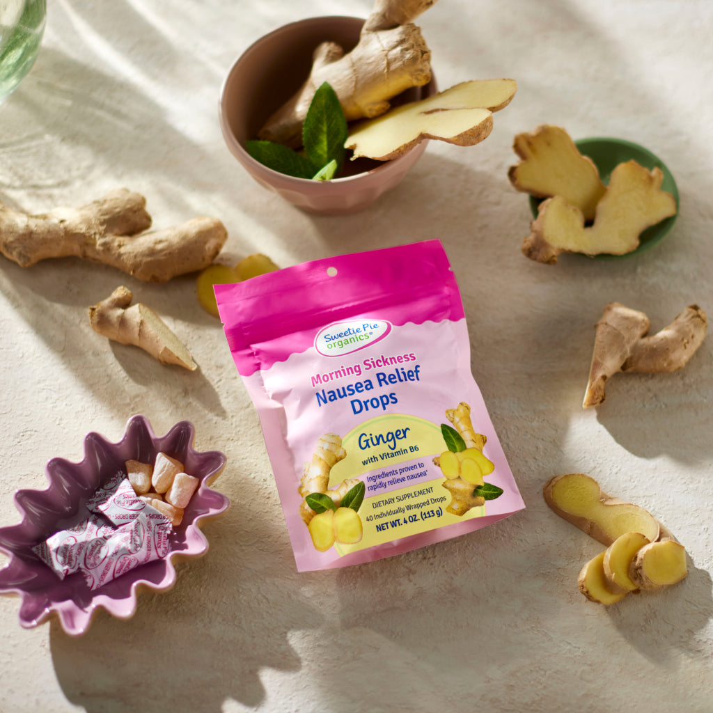 Image of Ginger Nausea Relief Drops in the Package surrounded by fresh ginger and the drops in a bowl