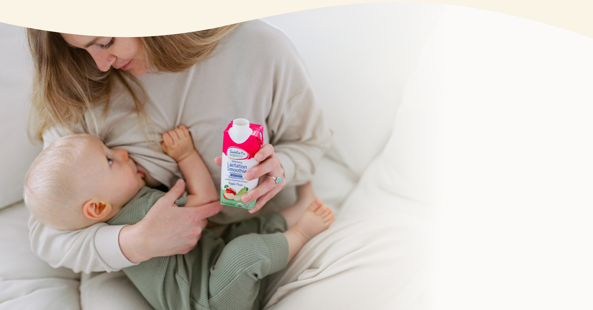 Mom breastfeeding her baby holding the apple pear lactation smoothie 